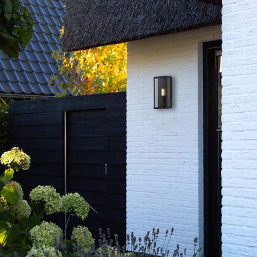 Zwarte wandlamp voor buiten met grote heldere beglazing in strak en modern gevellamp met vlakke achterzijde